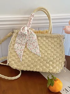 Bolso de playa trenzado beige con cinta floral y forro de cordón en mesa de madera