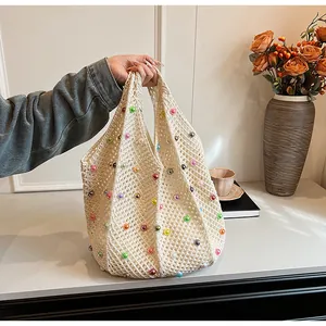 Detail of handmade cream crochet tote bag with multi-colored pearls for beach vacations