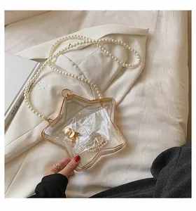 Gros plan du sac à main étoile en acrylique avec cadre doré et bandoulière perle