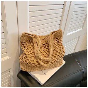 Détail du motif en crochet ajouré et de la doublure en tissu beige du sac de plage fourre-tout