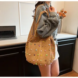 Detail of hand-crocheted beach tote with colorful faux pearls and mesh hollow pattern