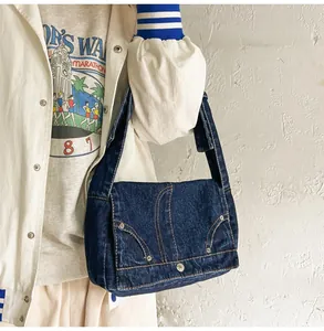Detailansicht der Vintage-Jeans-Schultertasche mit weißen Kontrastnähten und breitem Gurt