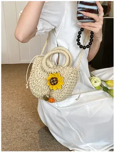 Dettaglio dell'applique girasole e della trama intrecciata della borsa di paglia a mano