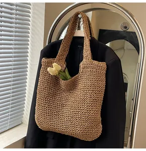Close-up of khaki woven straw tote bag with hollow crochet pattern and tulip detail