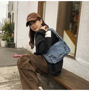 Detail der blauen Vintage-Denim-Umhängetasche mit Nieten und Wascheffekt