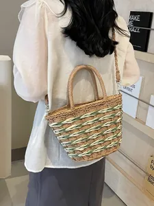 Handcrafted woven straw tote with green and cream stripes, featuring a round top handle