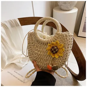 Dettaglio della borsa in paglia intrecciata con girasole giallo e fodera interna