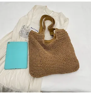 Flat lay of brown straw woven tote bag with comfortable fabric handles for beach vacations