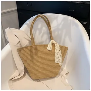 Detailed straw woven tote bag featuring a white lace strap and horizontal texture