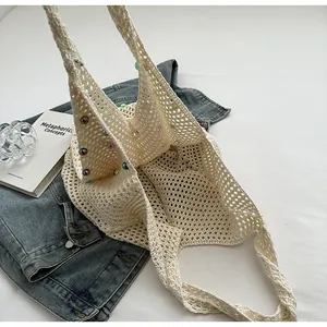 Detail of hand-woven off-white crochet beach bag with colorful beads and hollow knit design