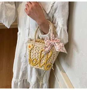 Close-up of woven straw bag with sunflower detail and a pink floral scarf on handle
