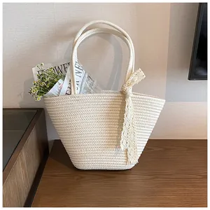 Detail of hand-woven beige tote bag with elegant lace ribbon and floral accents