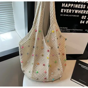 Detailed macro view of the cream crochet tote bag featuring colorful bead accents