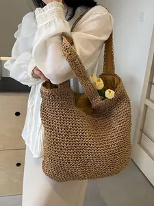 Large woven straw tote bag in dark khaki with shoulder strap for beach holidays