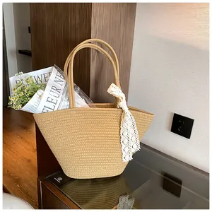 Detail of hand-woven straw tote bag with delicate white lace bow and flower decor