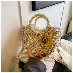 Dettaglio borsa in paglia con decoro girasole e chiusura a coulisse bianca