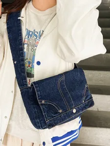 Vintage Denim Umhängetasche in Dunkelblau mit Nieten und breitem Gurt am Modell