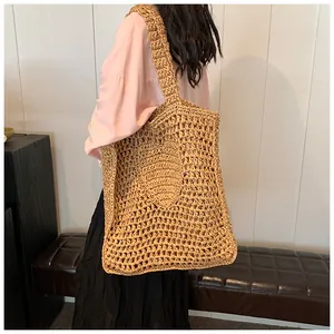 Detail of the oversized hollow crochet knit texture on a natural straw tote bag