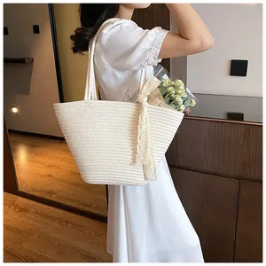 Close-up of woven straw tote bag featuring elegant side lace ribbon and fine texture