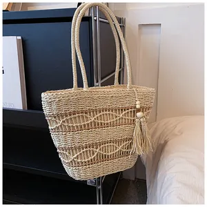 Detailansicht der Hohlwebtextur und Quastenverzierung an dieser Stroh-Strandtasche