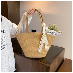 Detailed texture of hand-woven straw tote bag with elegant white lace ribbon handle detail
