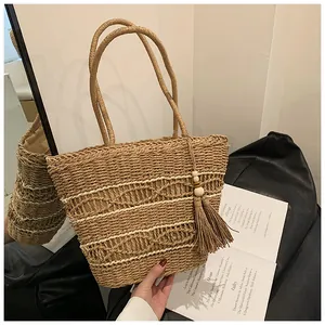 Detailansicht der Strohtasche mit Rautenmuster-Gewebe und Fransenanhänger mit Perlen