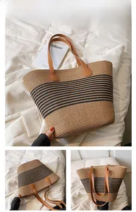 Detail of hand-woven straw tote with black stripes and brown leather handle stitching