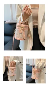 Detailed close-up showing pink floral embroidery and gold rivets on the bucket bag