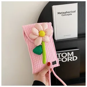 Détail d'un sac de téléphone tissé rose avec fleur en tissu 3D et étiquette Handmade
