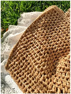 Close-up of hand-woven straw tote bag showing thick texture and rustic natural wood color