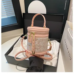 Close-up of pink floral embroidery bucket bag in a premium black gift box with satin