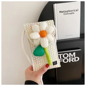 Détail d'un sac de téléphone tissé avec applique fleurie 3D et étiquette fait main
