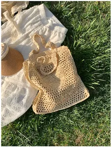 Detail of hollow-out hand-woven straw tote bag with intricate summer crochet texture