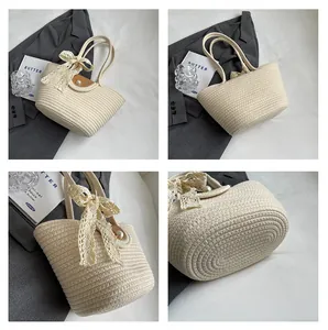 Vue détaillée du sac tissé beige avec fermoir perle et accessoire nœud en dentelle