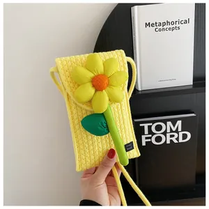 Détail d'un sac de téléphone tissé jaune avec fleur 3D et étiquette Hand Made