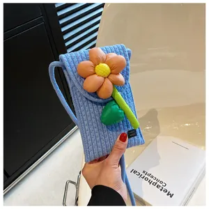 Détail du sac de téléphone tissé bleu clair avec grande fleur de tournesol 3D et patch