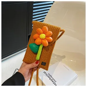 Détail du sac de téléphone tissé couleur gingembre avec fleur 3D et étiquette logo