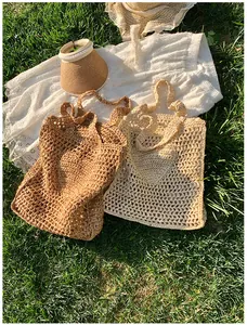 Close-up of hollow out handmade woven tote bags in brown and beige on sunny grass