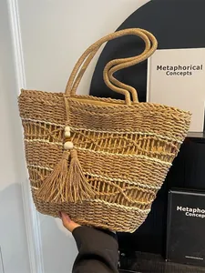 Handgewebte Stroh-Tote-Bag mit weißen Mustern und Quastenanhänger für den Strandurlaub