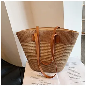 Detailed close-up of striped straw tote with premium leather straps and white stitching
