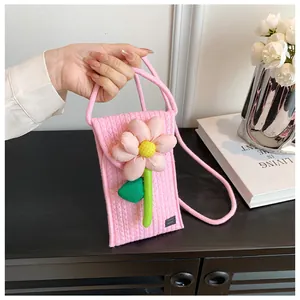 Détail d'un petit sac de téléphone matelassé rose avec fleur 3D et étiquette fait main