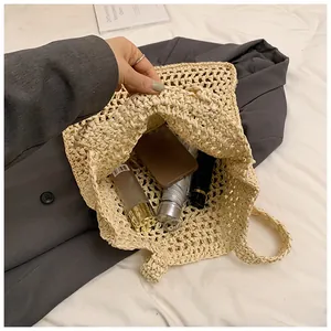 Detail view of large straw tote bag showing hollow-out texture and spacious interior