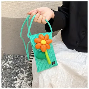 Vue détaillée du sac en tricot vert menthe avec fleur orange artisanale et logo