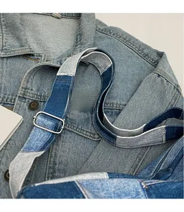 Details des verstellbaren Denim-Schultergurts mit silberner Metallschnalle auf der Tasche