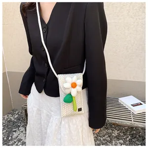 Détail d'un sac téléphone tressé avec marguerite 3D et motif de vagues colorées