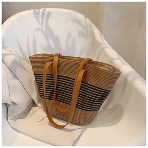 Detail of a large straw tote bag featuring a secure zipper closure and premium leather handles