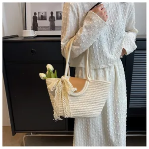 Détail d'un sac tissé avec nœud en dentelle, rabat en cuir perlé et décor de tulipe