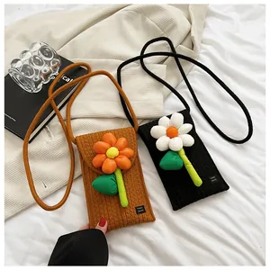 Gros plan du mini sac bandoulière tissé avec fleur 3D et étiquette fait main