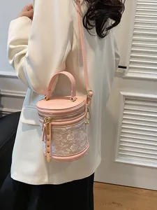 Pink cylinder bucket bag with floral embroidery and golden hardware for women