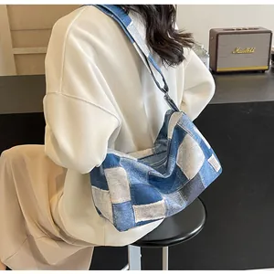 Detail view of patchwork denim shoulder bag showing texture and adjustable strap